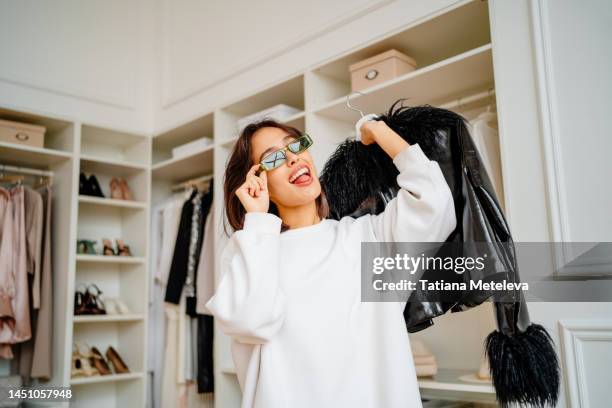 trendy female shopping in the clothes and boot boutique - walk in closet stock pictures, royalty-free photos & images