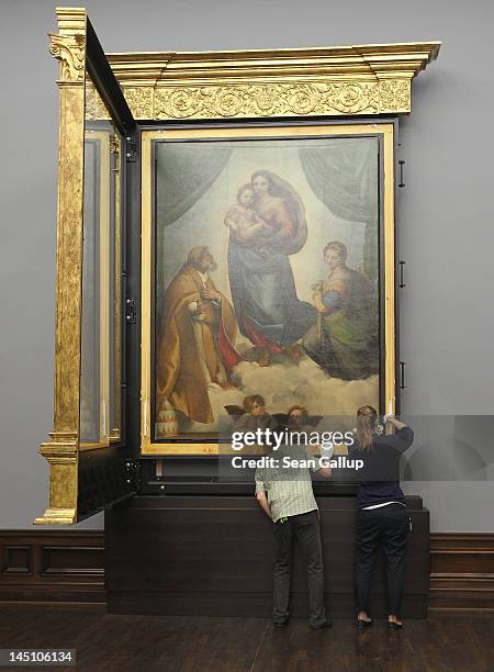 Gallery assistants finish hanging the „Sistine Madonna” painting by 16th century Italian painter Raphael in its new frame at the Galerie Alte Meister...