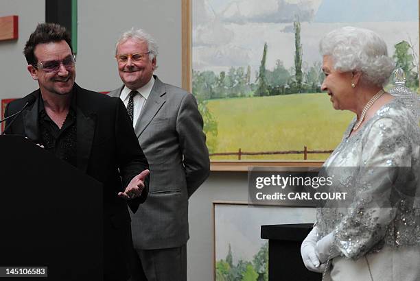 Britain's Queen Elizabeth II listens as Irish singer Bono makes a citation as she visits the Royal Academy of Arts in central London, on May 23,...