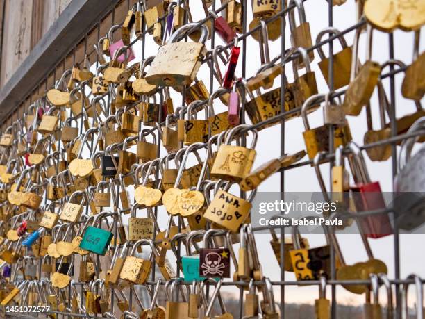 variety of padlocks hanging on a fence - kärlekslås bildbanksfoton och bilder