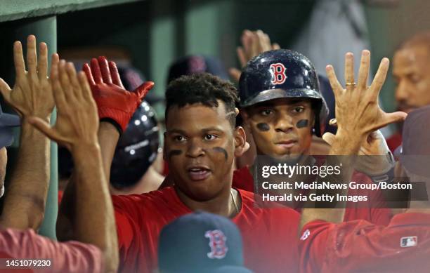 Rafael Devers and Xander Bogaerts come into high fives after Devers' two run homer in the second inning of the Red Sox vs. Yankees MLB game at Fenway...