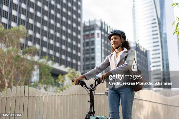 smiling businesswoman enjoying arriving to work by bicycle - classic press conference stock pictures, royalty-free photos & images