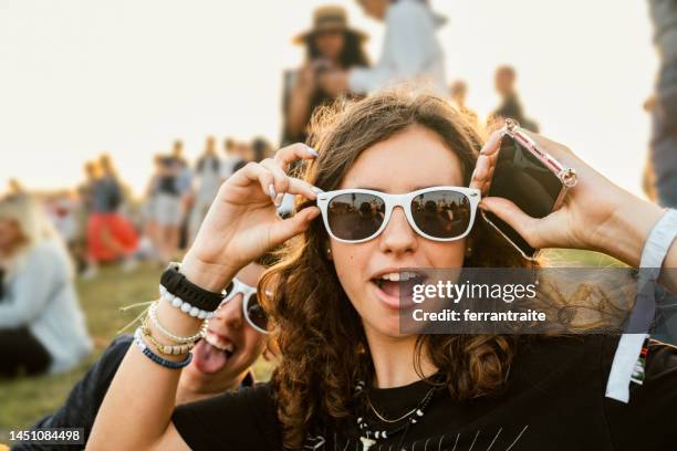 teenagers goofing around at music festival - trend stockfoto's en -beelden