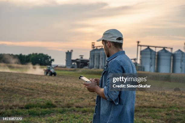 male farmer using drone remote controller in field - radio controlled handset stock pictures, royalty-free photos & images