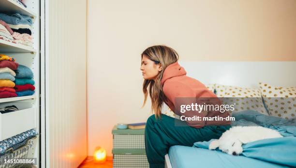 woman with stomach pain staying home - endometriosis stock pictures, royalty-free photos & images