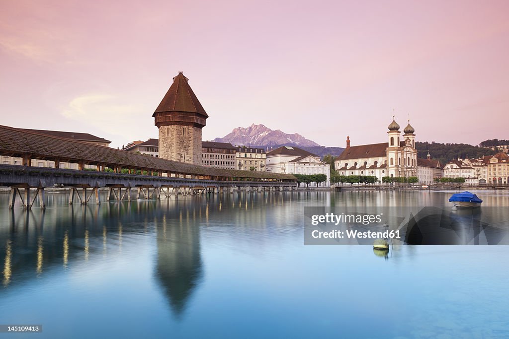 Switzerland, Lucerne, View of water tower, bridge and church in morning