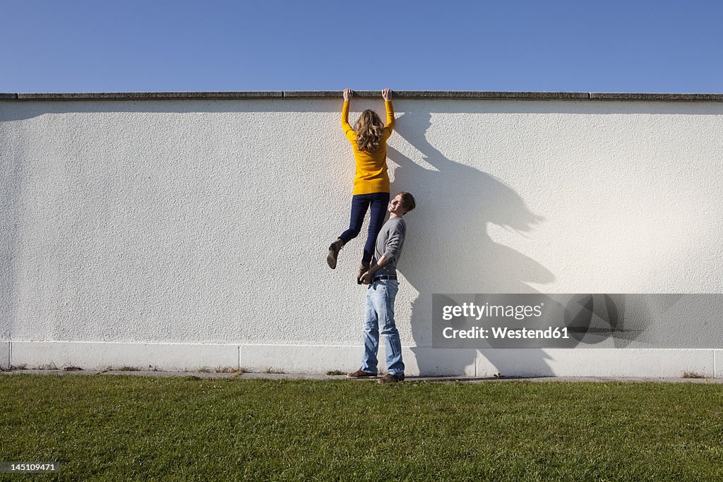 Germany, Bavaria, Munich, Young couple climbing wall