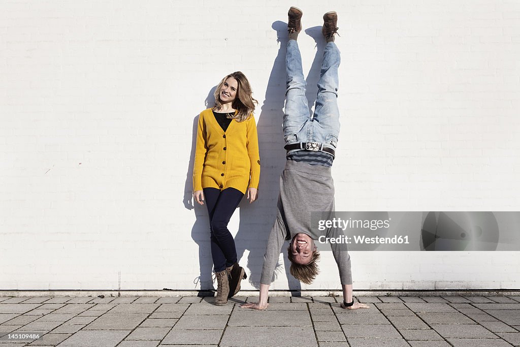 Germany, Bavaria, Munich, Young couple against wall, smiling