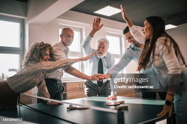 business colleagues are playing table tenis at work - women's table tennis stockfoto's en -beelden