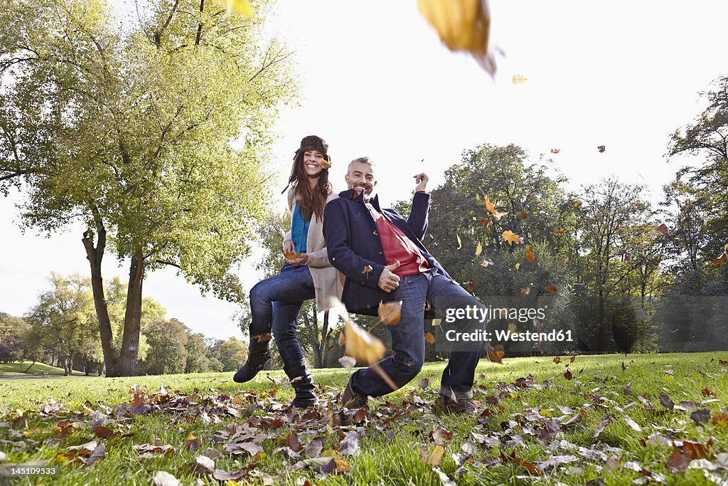 Germany, Cologne, Couple playing in park, smiling, portrait