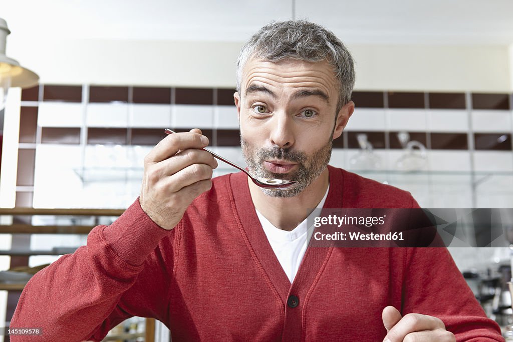 Germany, Cologne, Mature man holding spoon, portrait