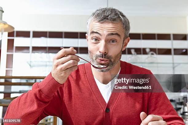 germany, cologne, mature man holding spoon, portrait - spion stock pictures, royalty-free photos & images