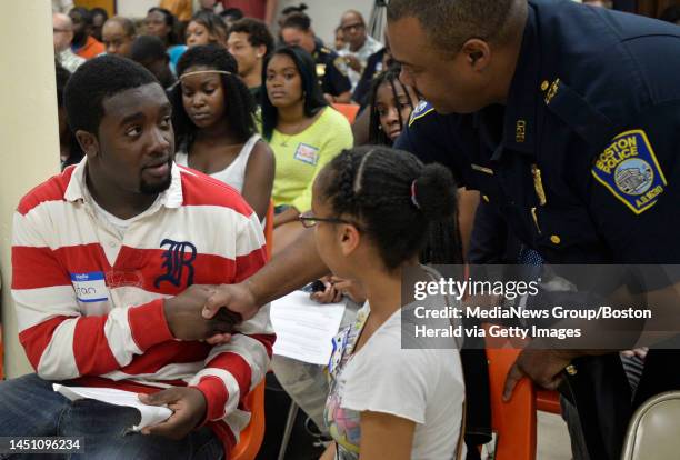 Year-old Stan Gourgue, left, shakes hands with Boston police Superintendent William G. Gross, right, as Anna Mercado looks on during a meeting to...