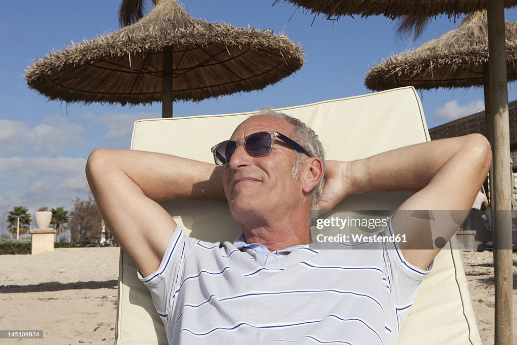 Spain, Mallorca, Senior man resting on deck chair at beach