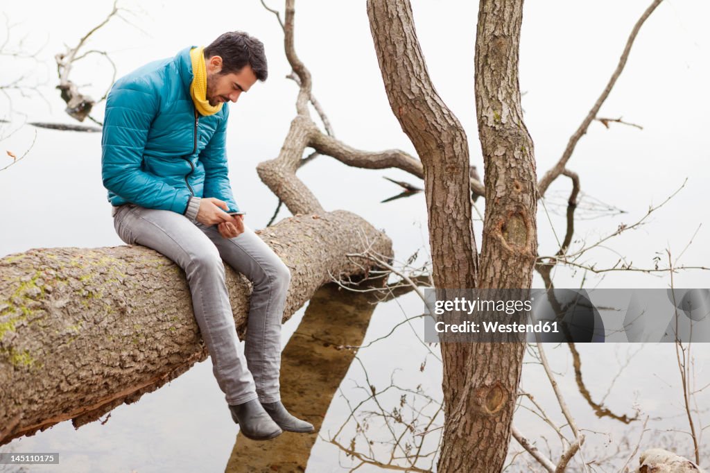 Germany, Berlin, Wandlitz, Young man using mobile phone