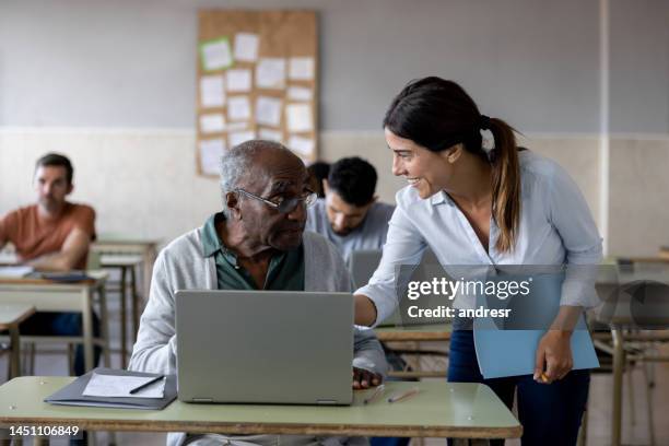 teacher assisting a senior adult taking a computer class - old computer lab stock pictures, royalty-free photos & images