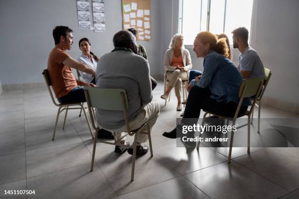 group of people talking in a therapy session - alcoholics anonymous stock pictures, royalty-free photos & images