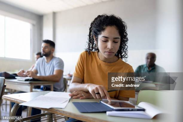 college student using a tablet computer in class - college application stockfoto's en -beelden