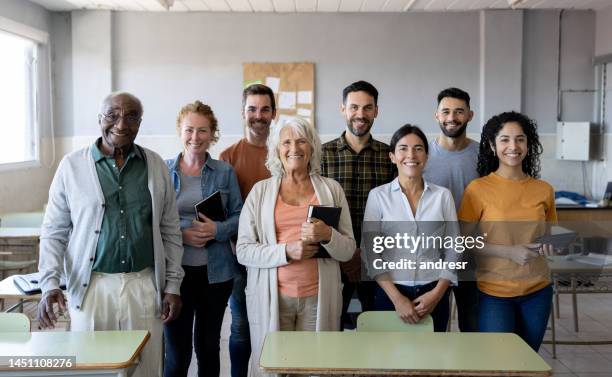 glückliche gruppe von schülern und lehrern, die im klassenzimmer lächeln - mittelgroße personengruppe stock-fotos und bilder