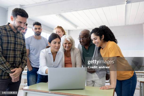 happy group of students in a computer class with their teacher - mature student stock pictures, royalty-free photos & images