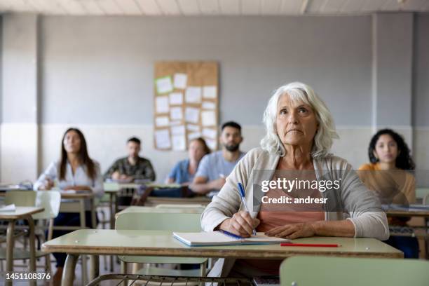 senior woman taking a class in college - avondschool stockfoto's en -beelden