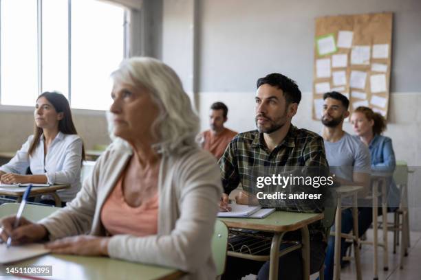 group of college students paying attention in class - avondschool stockfoto's en -beelden