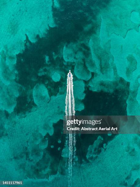drone image looking down on a speedboat crossing an ocean lagoon, new providence, bahamas - inlet stock pictures, royalty-free photos & images