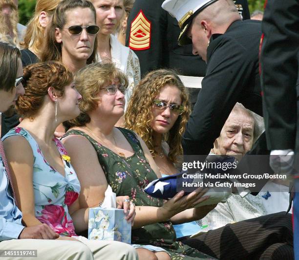 Marine Corps honor guard presents a folded US flag to Janet Racicot, the wife of Marine Master Gunnery Sgt. Dale Racicot at the New Hampshire...