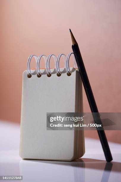 blank note pad and pencil against brown background,malaysia - open round two stock pictures, royalty-free photos & images