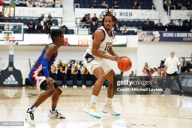 Brendan Adams of the George Washington Colonials dribbles the ball during a college basketball game against the American University Eagles at the...