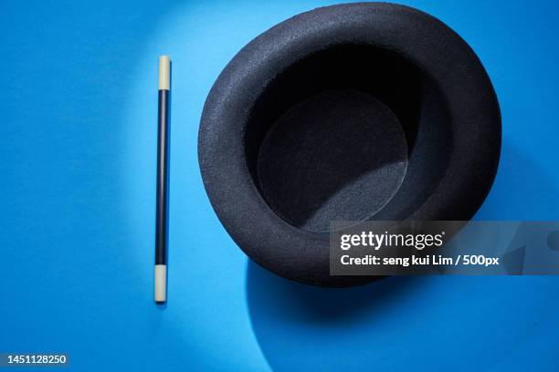 top view of top hot and magic wand against blue background,malaysia - chapeau haut de forme photos et images de collection