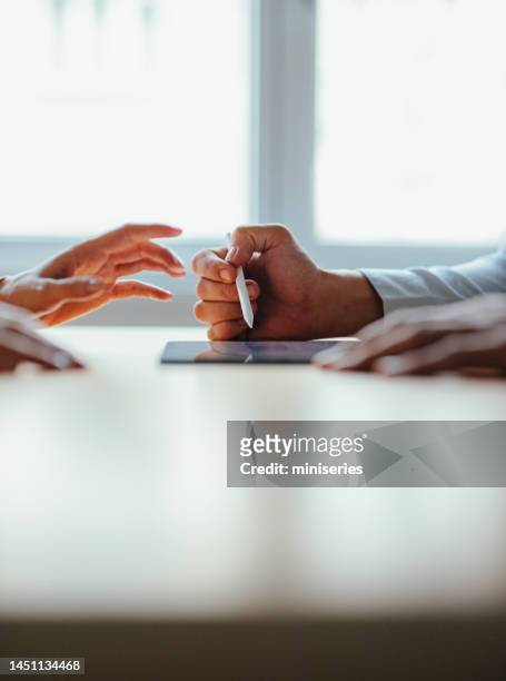 anonymous businesspeople analyzing business graph on a digital tablet - consultation at office desk imagens e fotografias de stock