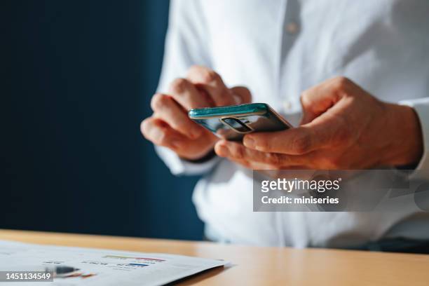 unrecognizable businessman using a mobile phone at home - close up table stock pictures, royalty-free photos & images