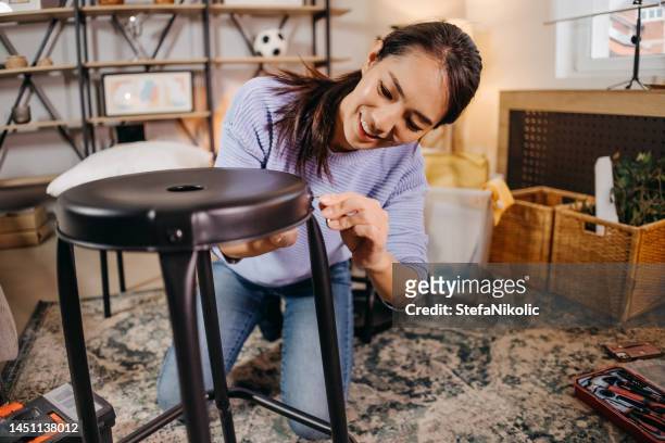 woman assembling a chair - schepping stockfoto's en -beelden