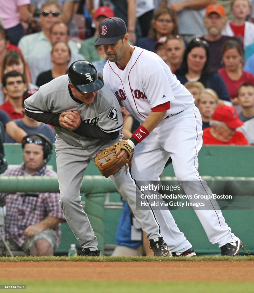 (082409 Boston, MA) Boston Red Sox third baseman Mike Lowell jokingly bumped into Chicago White Sox 3B coach Jeff Cox going for a foul ball rolling down the third base line in the 1s inning at Fenway Park on Monday, August 24, 2009. Staff Photo b
