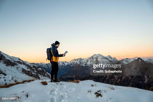 hiker looking at map in winter - beierse alpen stockfoto's en -beelden