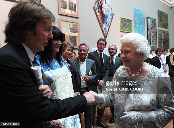 Britain's Queen Elizabeth II meets musician Paul McCartney as she visits the Royal Academy of Arts in central London, on May 23, 2012. AFP PHOTO /...