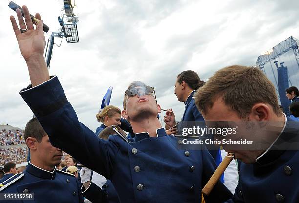 Air Force Academy graduate Paul Archambault, left, smokes a celebratory cigar after the graduation ceremony for the U.S. Air Force Academy at Falcon...