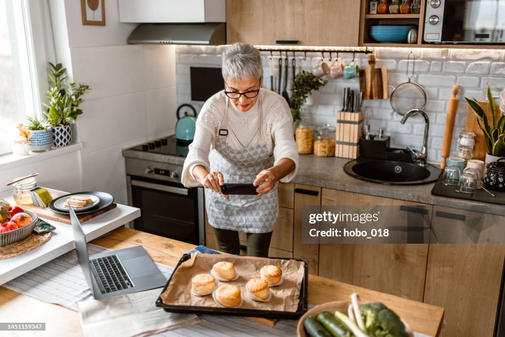 Frau, die ein Foto von Essen zum Kochen Blog macht.