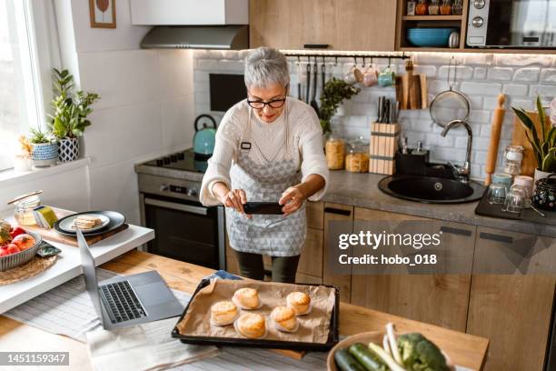 woman taking a photo of food for cooking blog. - side hustle stock pictures, royalty-free photos & images