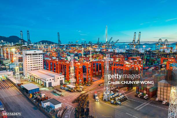 frachtschiff bei sonnenuntergang im hafen des containerhafens in hongkong - handelskrieg stock-fotos und bilder