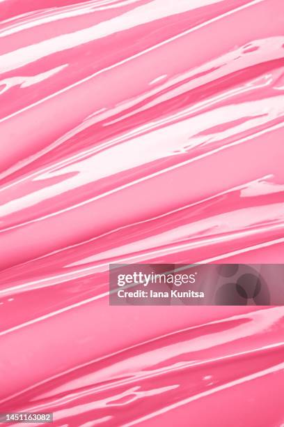 vertical texture of pink face cream is smeared. cosmetic products for makeup and skin care. - lipgloss stock-fotos und bilder