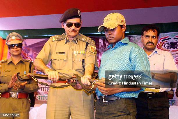 Maoist Sukhendu Baskey surrenders his rifle in the presence of DGP Naparajit Mukherjee on May 23, 2012 at Jhargram, West Midnapore in West Bengal,...