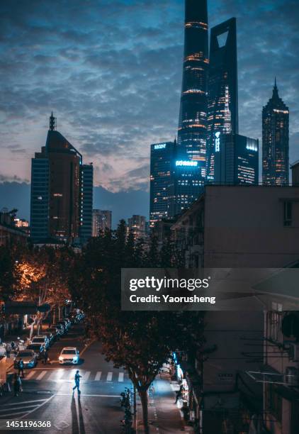 shanghai night: residential street versuns modern business buildings - people shanghai stockfoto's en -beelden