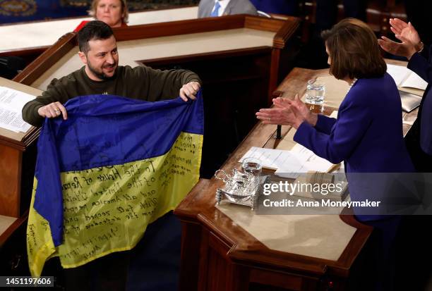 President of Ukraine Volodymyr Zelensky gives a Ukrainian flag signed by members of the Ukrainian military to U.S. Speaker of the House Nancy Pelosi...