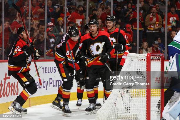 Brett Ritchie of the Calgary Flames celebrates with teammates after a goal against the Vancouver Canucks at Scotiabank Saddledome on December 14,...