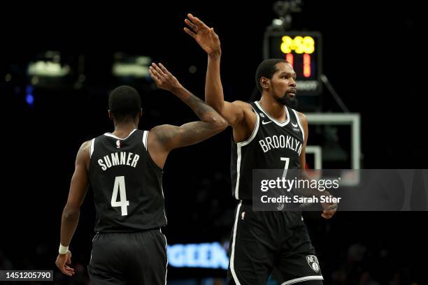 Kevin Durant and Edmond Sumner of the Brooklyn Nets celebrate a play against the Golden State Warriors during the first half of the game at Barclays...