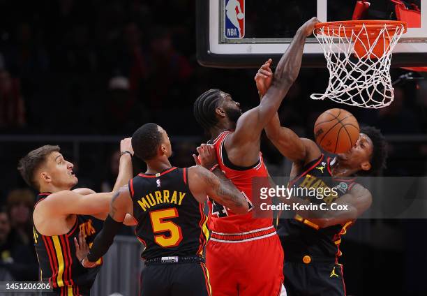 Patrick Williams of the Chicago Bulls dunks over De'Andre Hunter, Dejounte Murray and Bogdan Bogdanovic of the Atlanta Hawks during the first quarter...
