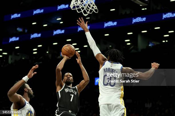 Kevin Durant of the Brooklyn Nets shoots the ball against James Wiseman and Jonathan Kuminga of the Golden State Warriors during the first half of...