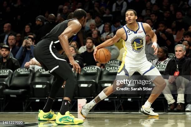 Jordan Poole of the Golden State Warriors dribbles against Kevin Durant of the Brooklyn Nets during the second half of the game at Barclays Center on...